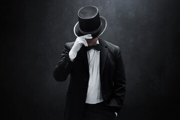 Mysterious man in black suit on dark background - obrazy, fototapety, plakaty