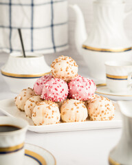 White and pink chocolate covered bun in a coffe time table