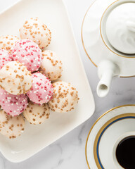 White and pink chocolate covered bun in a coffe time table