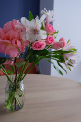 Fototapeta premium bouquet of flowers in a glass jar on wooden table in modern interior