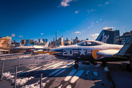 View of a F-9 Cougar fighter jet on the flight deck of USS Intrepid Sea, Air and Space Museum in front of the Manhattan skyline, New York, NY, USA