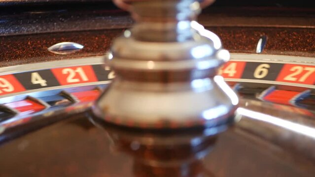 Ball on wooden french roulette table in casino. Wheel spinning, turning or rotating. Odd and even numbers, black, red and zero sectors. Bets in game of chance. Money playing, gambling or risky betting