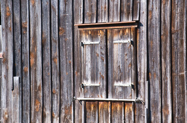 Verwitterte Holzfassade mit Fensterladen