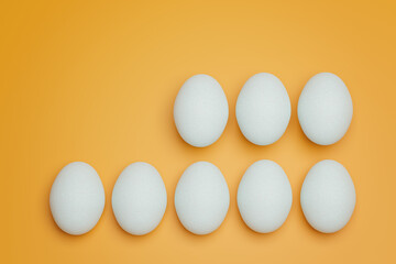 Eight white chicken eggs on yellow background top view. Creative food minimalistic background.