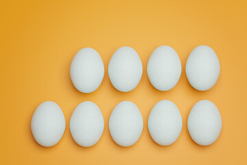 Nine white chicken eggs on yellow background top view. Creative food minimalistic background.