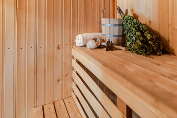 Traditional old Russian bathhouse SPA Concept. Interior details Finnish sauna steam room with traditional sauna accessories set basin birch broom towel aroma oil. Relax country village bath concept