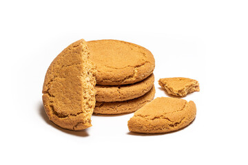 A stack of crunchy ginger biscuits with one of them broken into three pieces