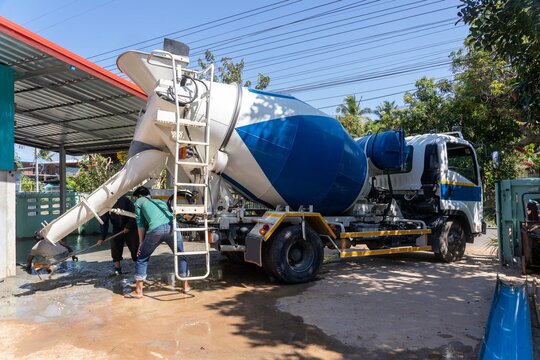 Workers pouring concrete with a cement mixer truck.