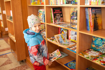 A little boy picks out books in a bookstore.