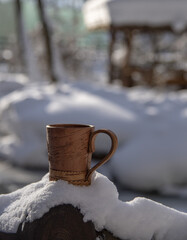 Birch bark mug on the background of a winter sunny landscape. Dishes made of environmentally friendly materials.