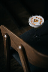  White cocktail with caramelized orange on dark blue chair.