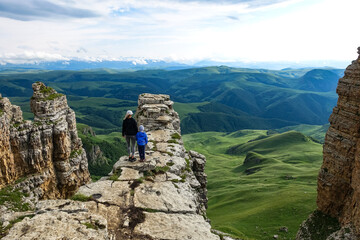 A girl with a child on the background of the mountains and the Bermamyt plateau in Russia. June 2021