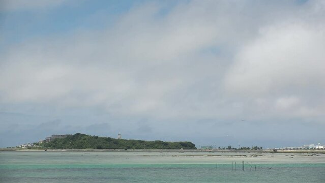 TOMIGUSUKU, OKINAWA, JAPAN - AUGUST 2021 : View of Senaga island and beach (Ocean or sea) in daytime. Clear blue summer sky and clouds. Holiday, vacation and resort concept video.