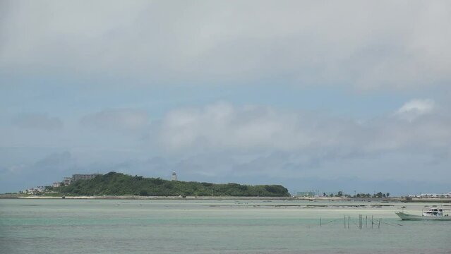 TOMIGUSUKU, OKINAWA, JAPAN - AUGUST 2021 : View of Senaga island and beach (Ocean or sea) in daytime. Clear blue summer sky and clouds. Holiday, vacation and resort concept video.