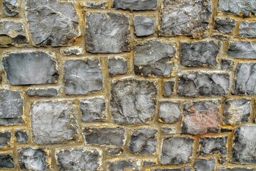 Stone wall made of different size rocks and concrete. Mason craft and skill. Graphic and design background.