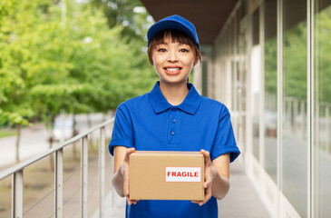 profession, job and people concept - happy smiling delivery woman or postwoman in blue uniform...