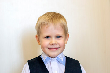 Little blond boy in a shirt and vest