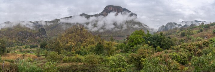 Naklejka na ściany i meble Scenic morning rural panorama of beautiful agricultural mountain valley with low clouds in the Chiang Dao countryside, Chiang Mai, Thailand