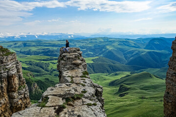 A girl on the background of the mountains and the Bermamyt plateau in Russia. June 2021