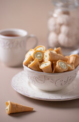 Tea party with sweets on beautiful white plates and beige background