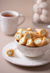 Tea party with sweets on beautiful white plates and beige background