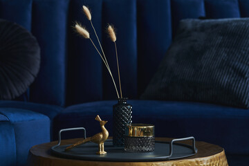 Stylish close up on the elegant details in the glamour living room interior. Golden peacock and...