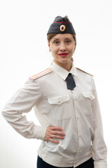 A beautiful young female Russian police officer in dress uniform in a cap and a white shirt smiles...