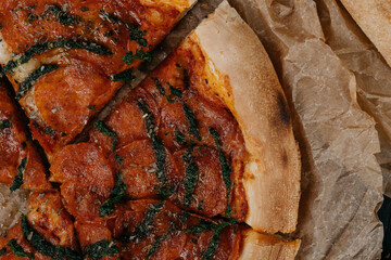 Close up Delicious pepperoni pizza served on parchment paper 