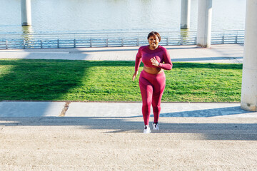 Fototapeta na wymiar Young black woman exercising, running up steps
