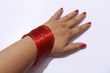Woman`s hand with many Red colour bangles on her wrist Isolated white background