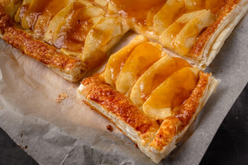 Slice of homemade apple pie with marmalade in dark mood photo style.