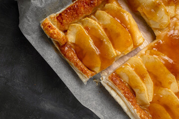 Slice of homemade apple pie with marmalade in dark mood photo style.
