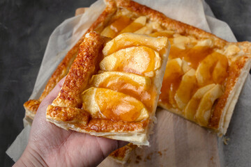 Slice of homemade apple pie with marmalade in dark mood photo style.