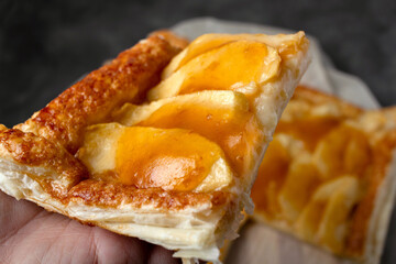 Slice of homemade apple pie with marmalade in dark mood photo style.