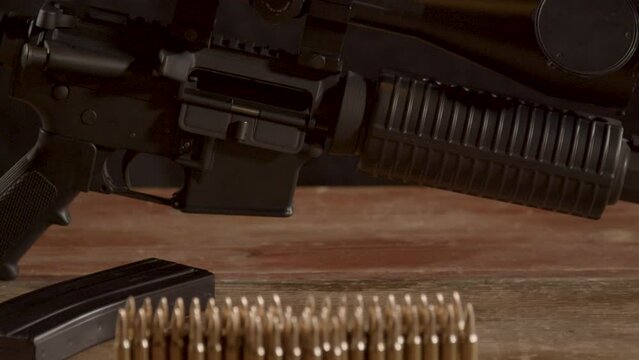Dolly of .223 ammunition standing on a wood surface, tilting up to empty AR-15 rifle