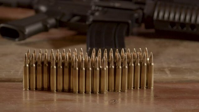 Dolly out of 5.56mm ammunition standing on wooden surface with an AR-15 in the background