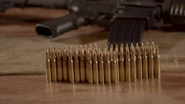 Dolly of 5.56mm ammunition standing on wooden surface with an AR-15 in the background