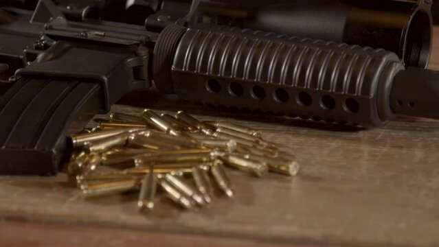 Close dolly in of a lot of ammunition lying in front of AR-15 rifle