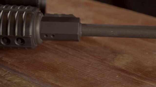 Close dolly over AR-15 barrel on a wooden surface