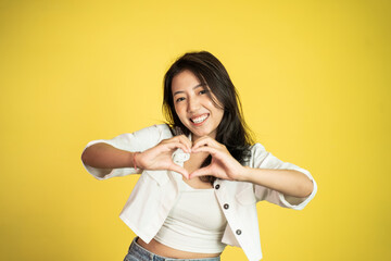 young woman laughing with heart shape with fingers