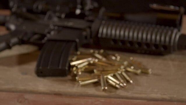 Wide dolly out of AR-15 with a lot of ammunition lying on wooden surface