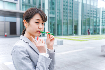 電子タバコを吸う若いビジネスウーマン