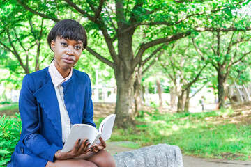 公園で読書をする黒人女性