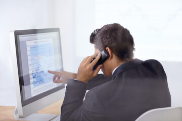Look at those share prices. Shot of a businessman talking on the phone and pointing at a graph on his computer screen.