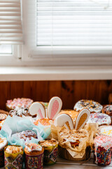 Traditional Ukraine Easter cake with icing and hand painting eggs.Homemade muffins with powdered sugar. Rustic style.