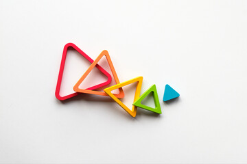 Nested wood triangles in rainbow colors. Concentric educational figures. Baby stacking puzzle....