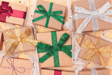 Gifts tied with colorful ribbons on a golden background with confetti. Boxing day concept.