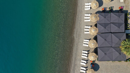 Aerial top view photo of sun beds and umbrellas in popular tropical paradise deep turquoise...