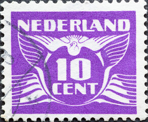 Netherlands - circa 1941: a postage stamp from the Netherlands, showing a stylized graphic. Flying Dove with a number 10 cent  purple
