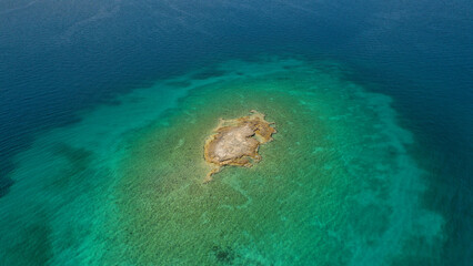 Fototapeta na wymiar Aerial drone photo of small paradise tropical island and sandy beach forming an emerald clear sea lagoon